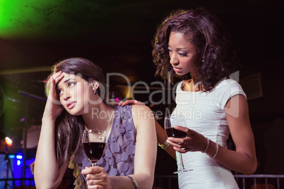 Woman having drinks and comforting her depressed friend