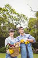 Young couple holding a basket of freshly harvested vegetables