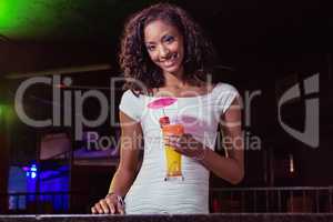 Portrait of young woman having a cocktail at bar counter