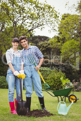 Young couple holding shovel and spading fork