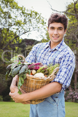 Man holding a basket of freshly harvested vegetables