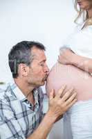 Man kissing the belly of pregnant woman