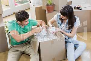 Young couple unpacking carton boxes in their new house