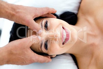 Pregnant woman receiving a head massage from masseur