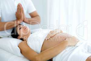 Pregnant woman receiving a spa treatment from masseur