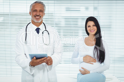 Doctor and pregnant woman smiling at camera