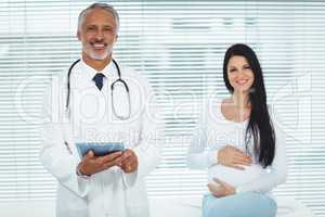 Doctor and pregnant woman smiling at camera