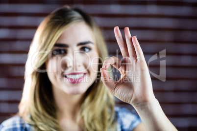 Pretty blonde woman making signs with her fingers