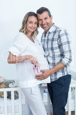 Pregnant couple holding baby shoes