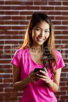 Smiling asian woman using smartphone