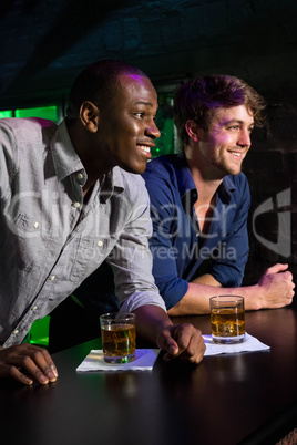 Two men having whiskey at bar counter