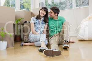 Young couple sitting together on the floor and smiling