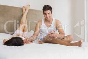 Couple talking to each other while relaxing on bed