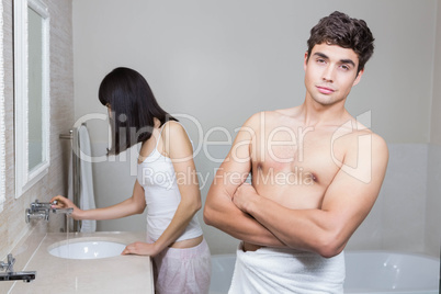 Man looking at camera and woman standing near sink