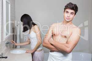 Man looking at camera and woman standing near sink