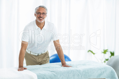 Physiotherapist standing near massage table