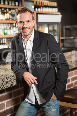 Handsome man leaning his elbow on the counter