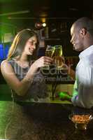 Couple toasting their beer glasses at bar counter