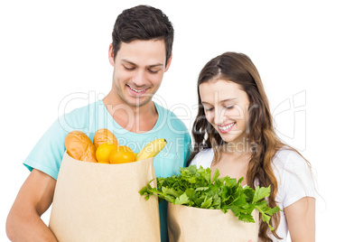 Happy couple carrying grocery bags