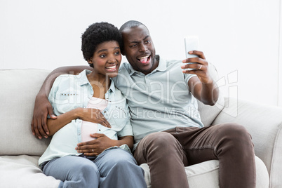 Pregnant couple taking a selfie on mobile phone