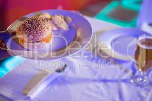 Plate of burger and beer glass on table