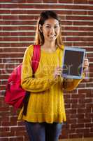 Smiling asian female student showing tablet