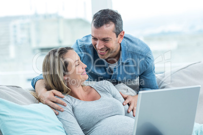 Couple using laptop in living room