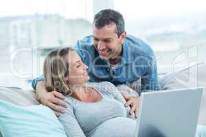 Couple using laptop in living room