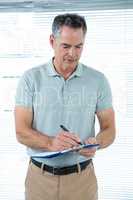 Man writing down notes in office