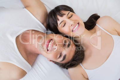 Happy couple lying on bed