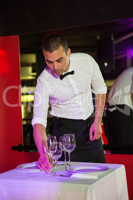 Waiter setting a table