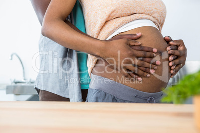 Pregnant couple embracing in kitchen