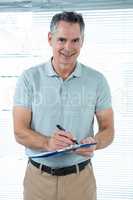 Man writing down notes in office