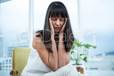 Pregnant woman sitting with headache