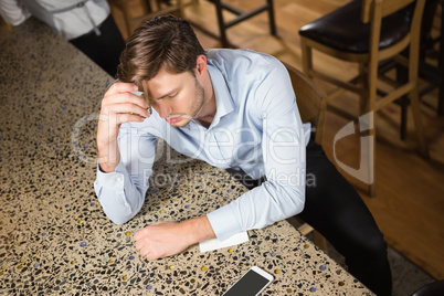 Tired man leaning his elbow on the counter