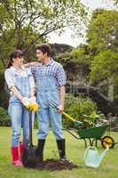 Young couple holding shovel and spading fork