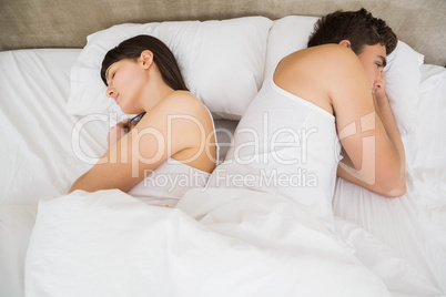 Couple sleeping back to back after an argument