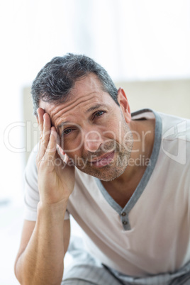 Worried man sitting on bed