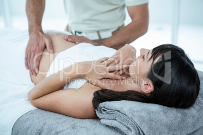 Pregnant woman receiving a stomach massage from masseur