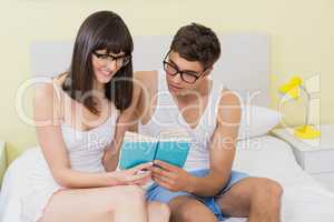 Young couple reading a novel on bed