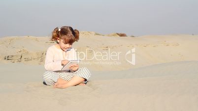 little girl play with tablet in desert