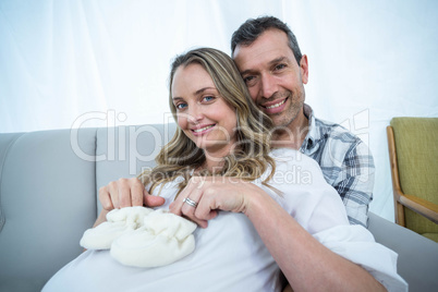 Pregnant couple sitting on sofa