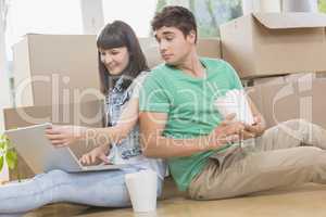 Young couple eating noodle and using laptop
