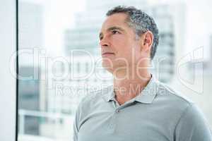 Tensed man standing against window