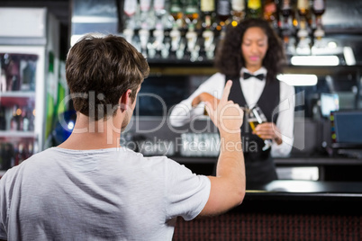 Man ordering a drink at bar counter