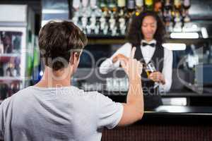 Man ordering a drink at bar counter