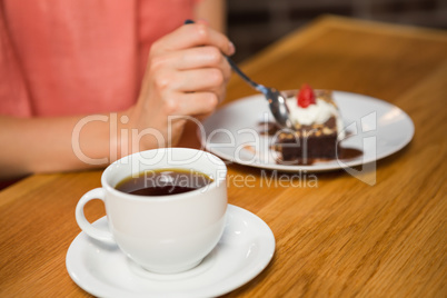 Pretty woman having coffee and brownie