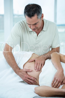 Pregnant woman receiving a stomach massage from masseur