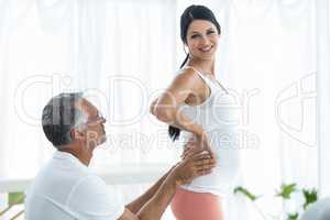 Doctor giving physiotherapy to pregnant woman