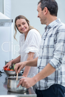 Man helping pregnant woman prepare food
